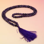 Amethyst 108 Mala Necklace on pink and orange background