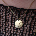 Someone wearing the Aquarius 14k Gold Dipped Nickel-Free Zodiac Necklace with a black net top.