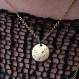 Someone wearing the Aquarius 14k Gold Dipped Nickel-Free Zodiac Necklace with a black net top.