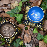 Decorative bowls with intricate designs on a bed of leaves and greenery