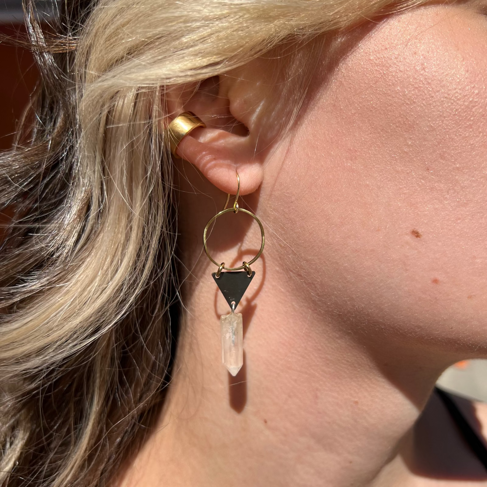 A woman wearing the Brass Quartz Crystal Triangle 2 inch. Earrings.