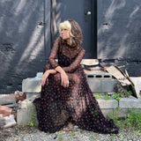 Close-up of the cherry mesh dress as the woman sits, highlighting the print and sheer fabric.