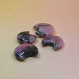 Four semi-precious stones with a colorful pattern on a beige background