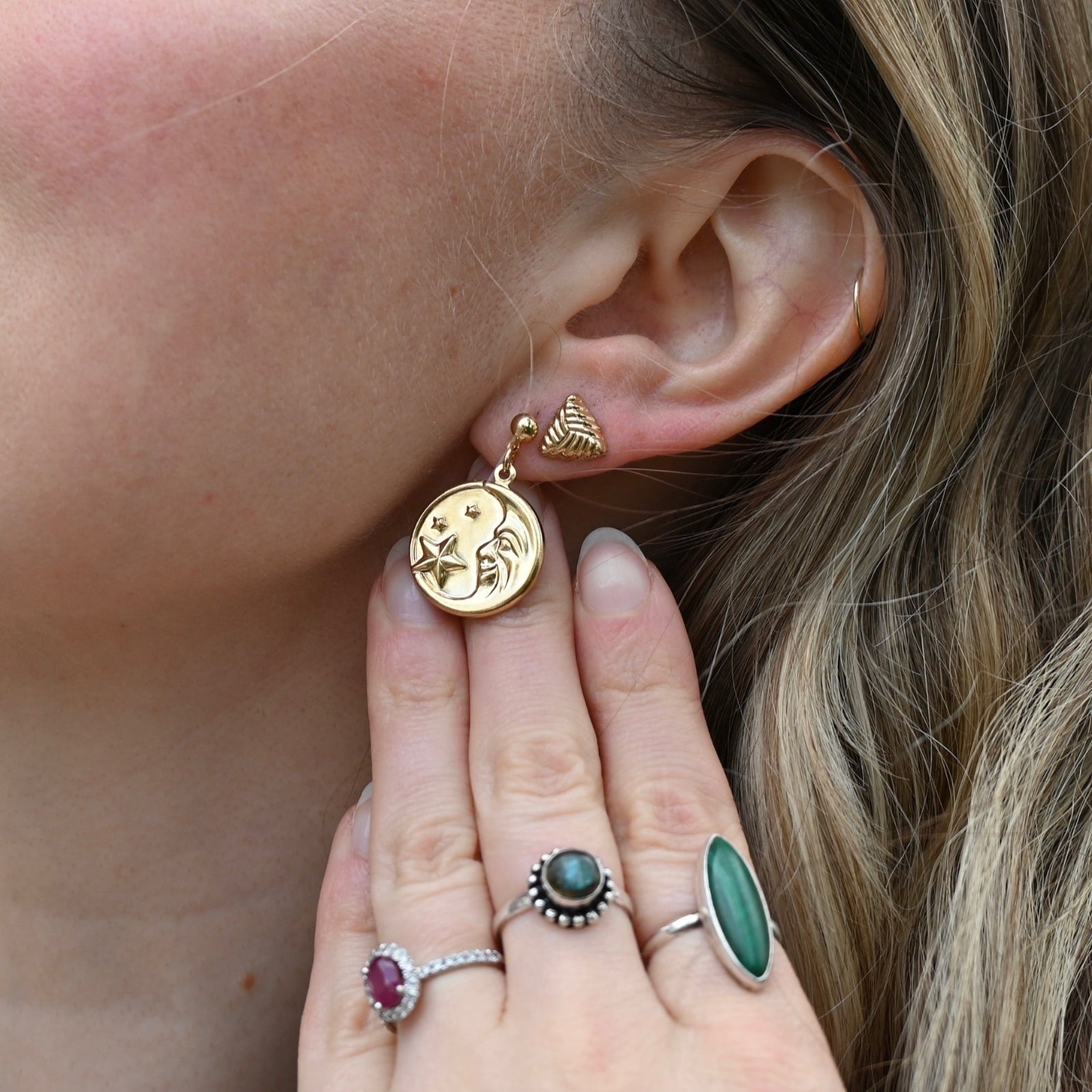 An up-close image of someone wearing the Vintage Moon & Stars Earrings.