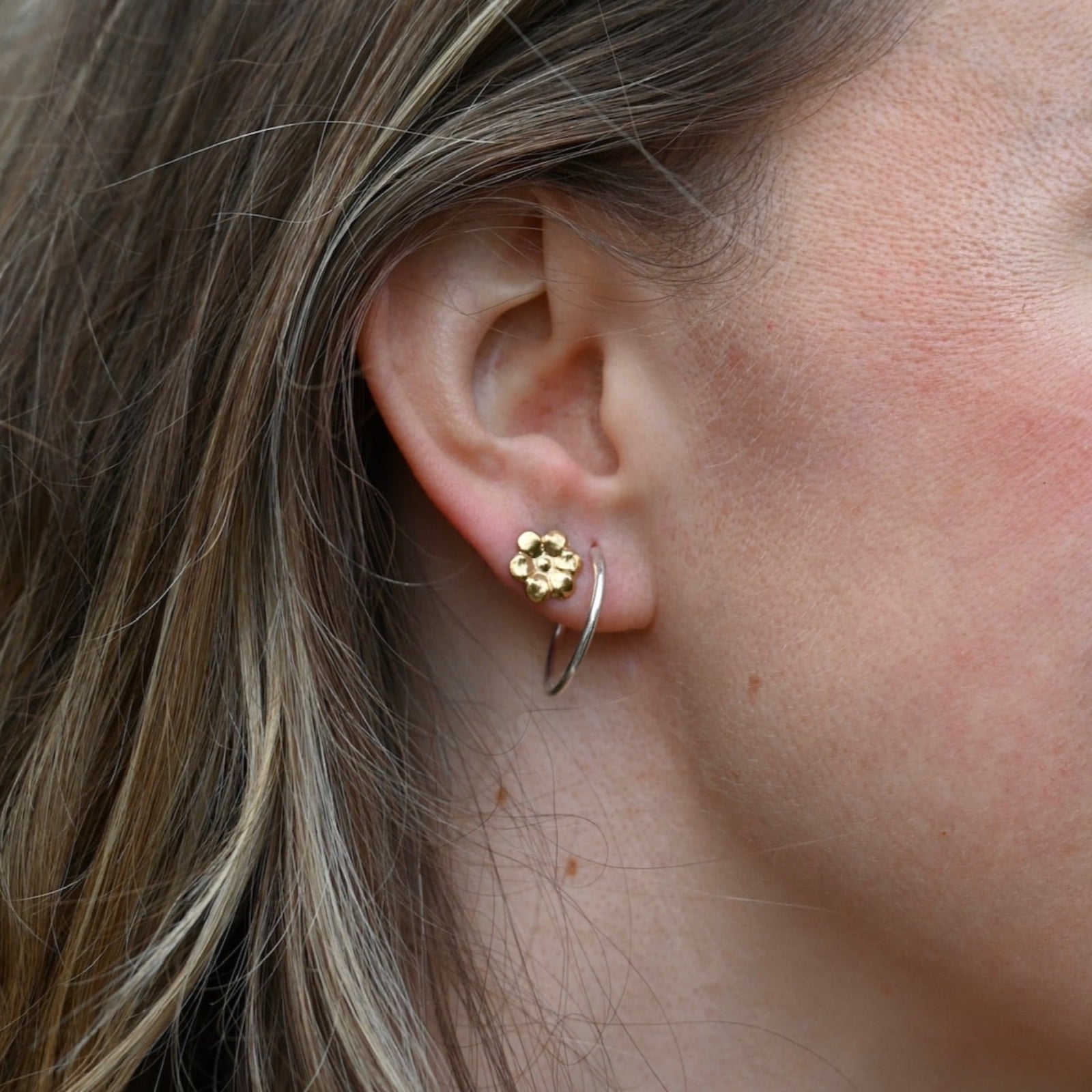 Someone wearing the silver Vintage Endless Hoops Earrings.