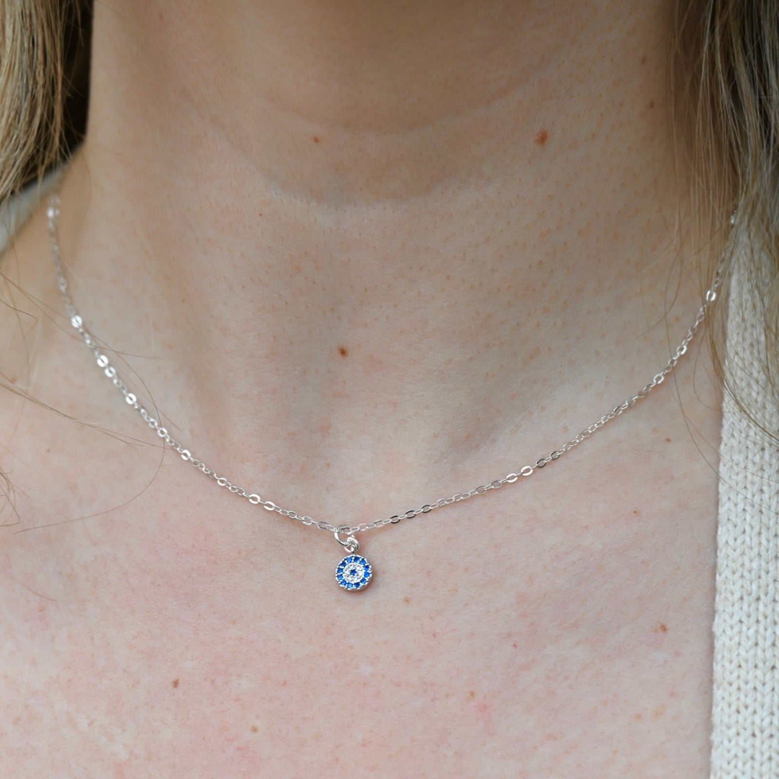 Someone wearing the Sterling Silver Dainty Blue Evil Eye Necklace.