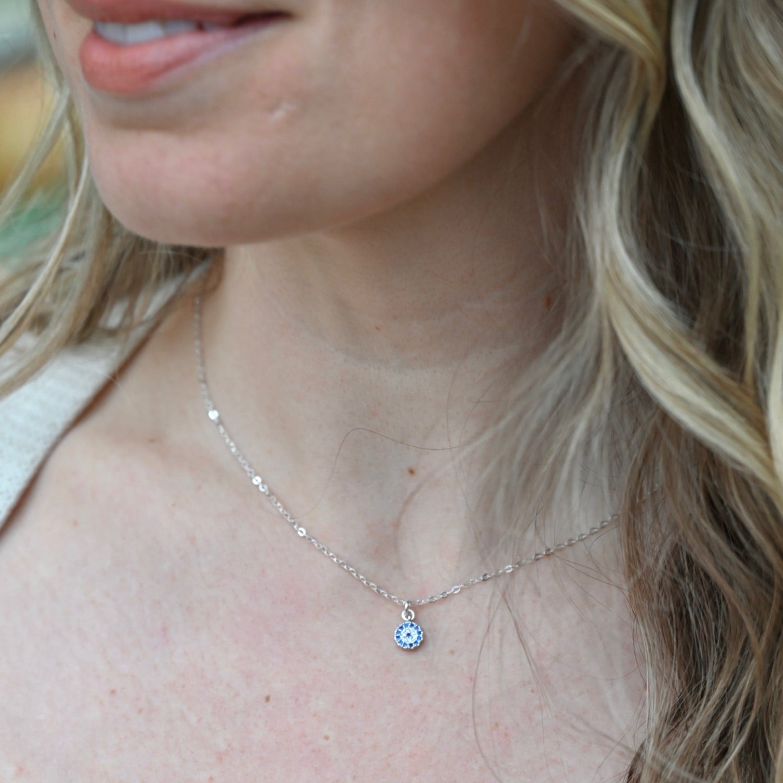 Someone wearing the Sterling Silver Dainty Blue Evil Eye Necklace.