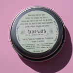 The back of the North Country Salve on a pink background.