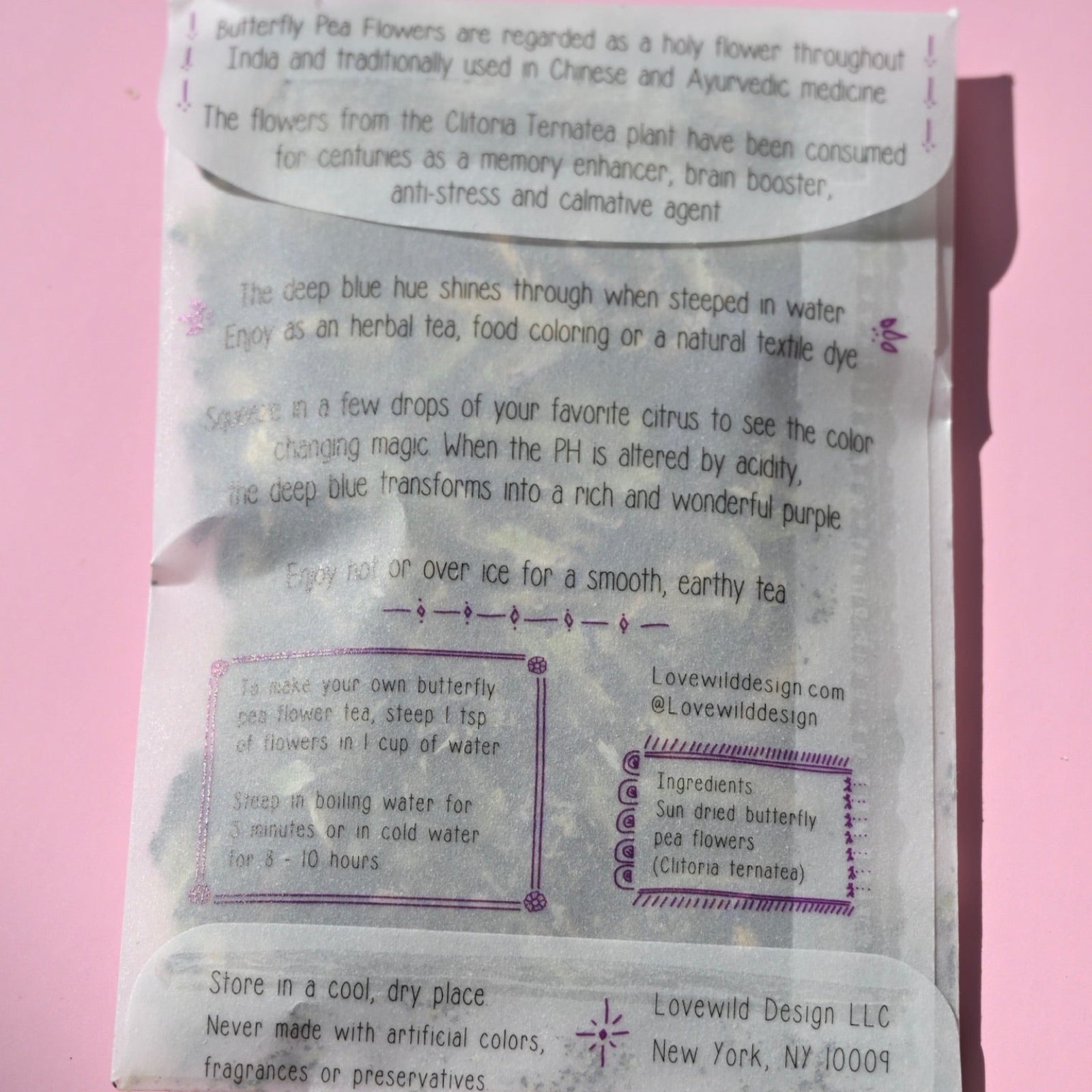 The back of the Butterfly Pea Flower Tea on a pink background.