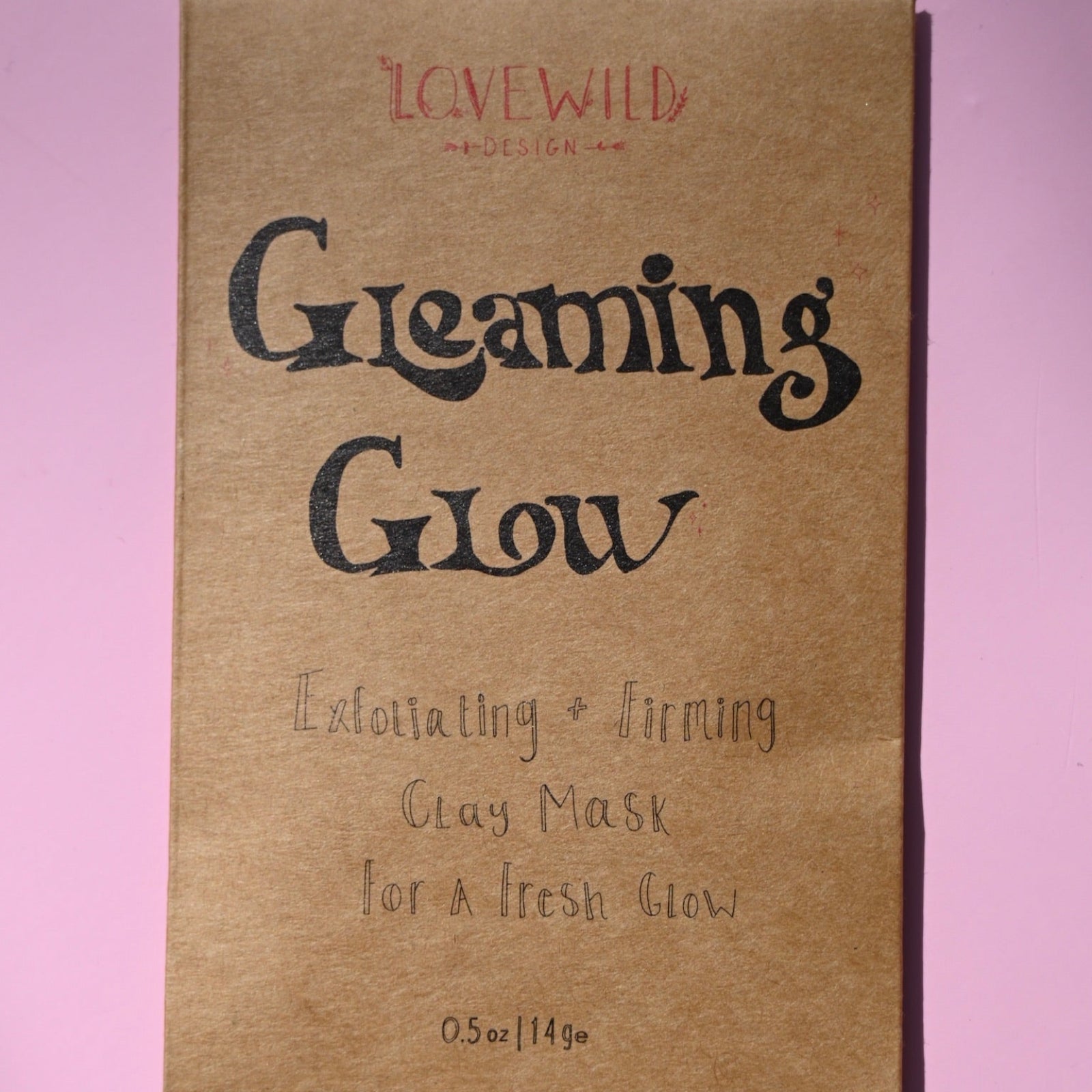 The Gleaming Glow Clay Face Mask on a pink background.