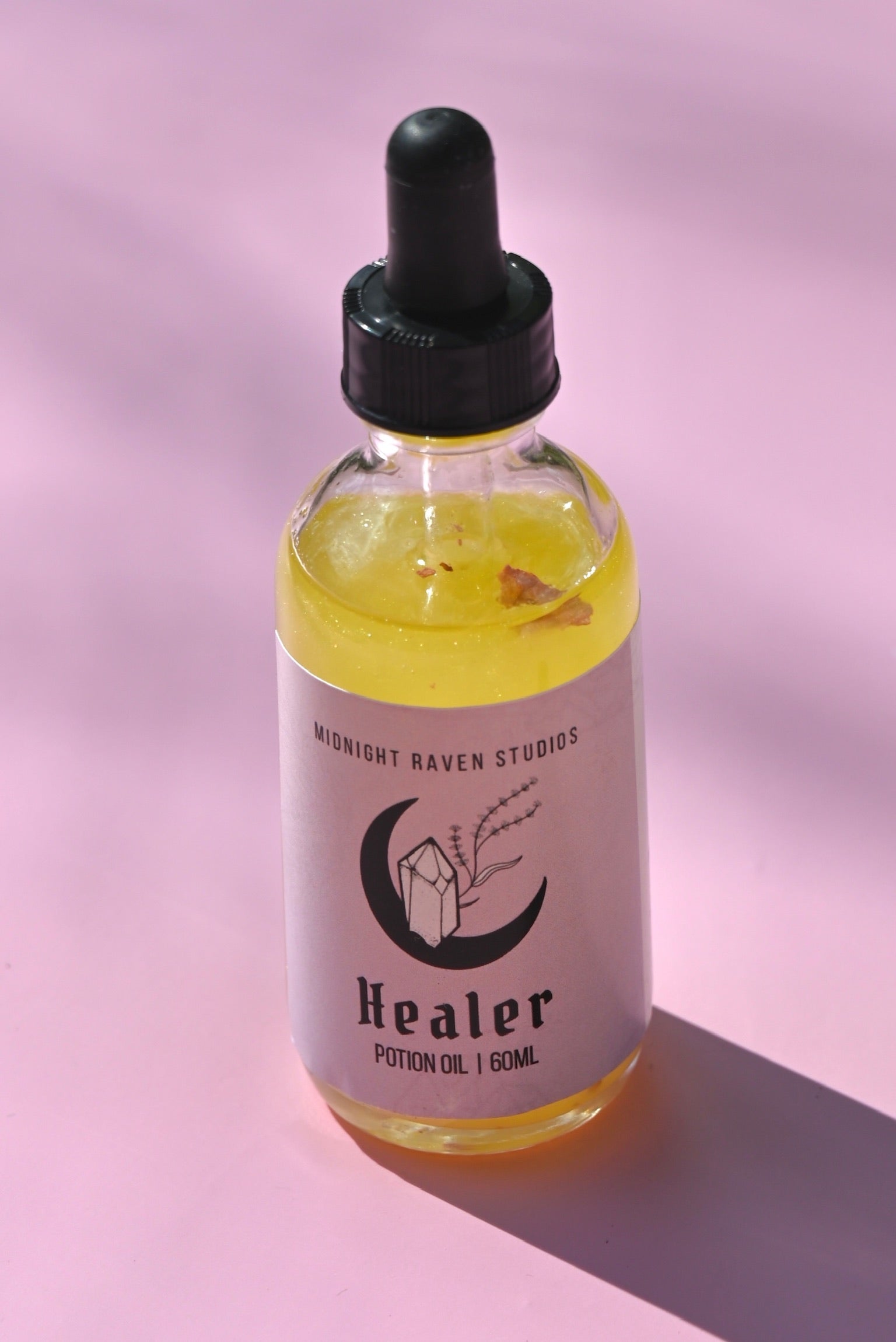 The Healer Potion Body Oil - Lavender Rose Body Oil on a pink background.