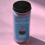 The Chill the F*ck Out Spell Candle with Herbs and Crystals on a pink background.