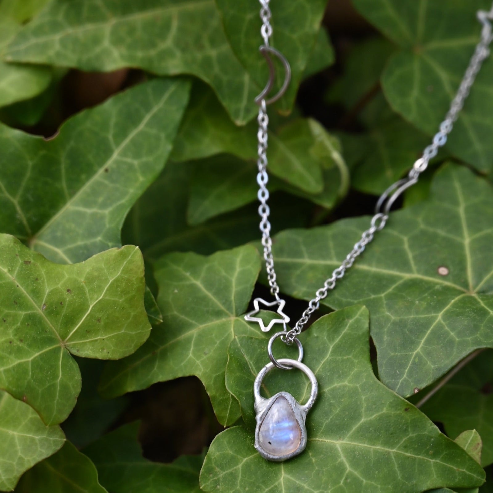 The Moonstone Sterling Silver Celestial Necklace on a green leaf.