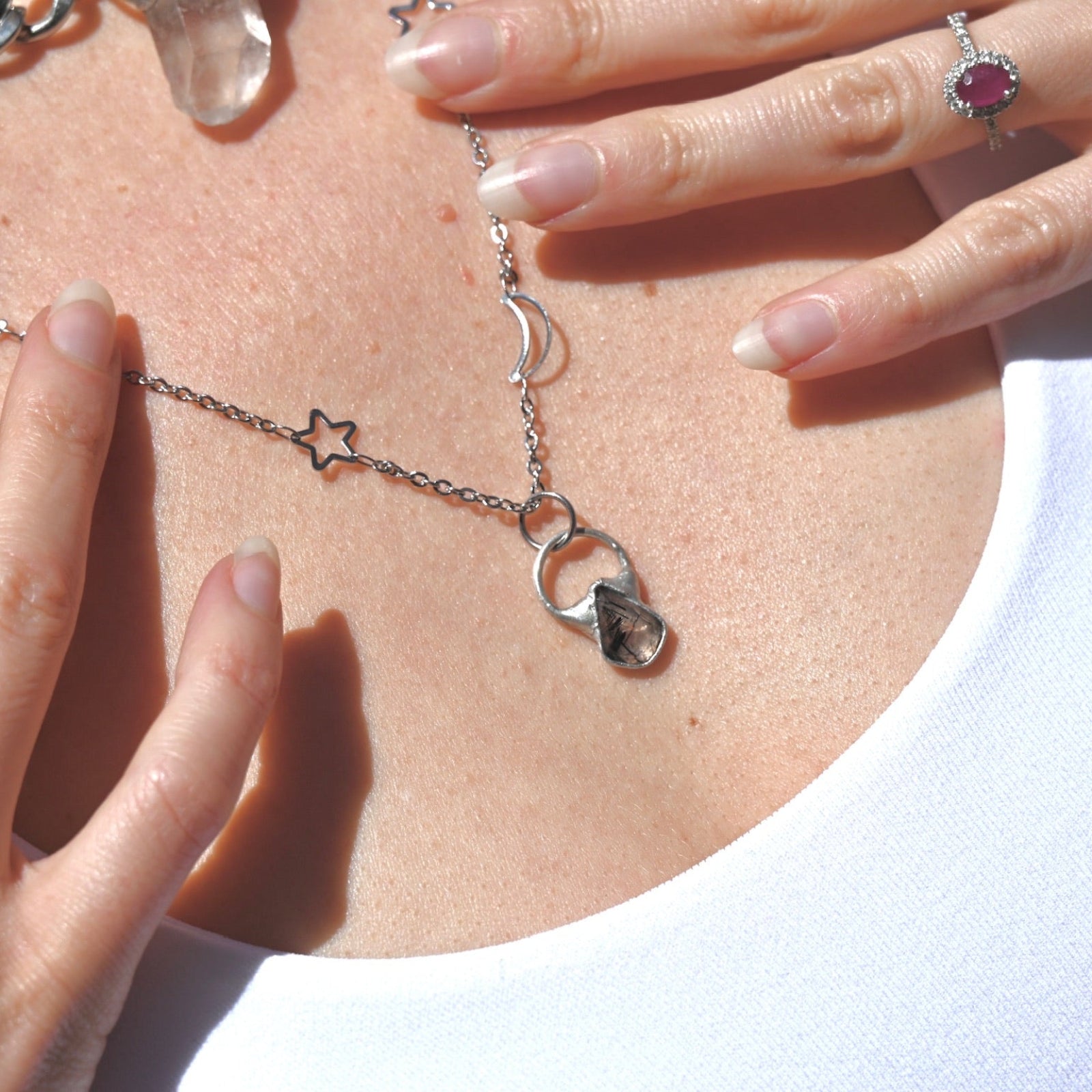 Someone wearing the Black Rutile Sterling Silver Celestial Necklace.