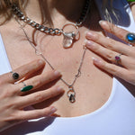 Someone wearing the Black Rutile Sterling Silver Celestial Necklace and the Clear Quartz Athena Thick Chain Necklace.