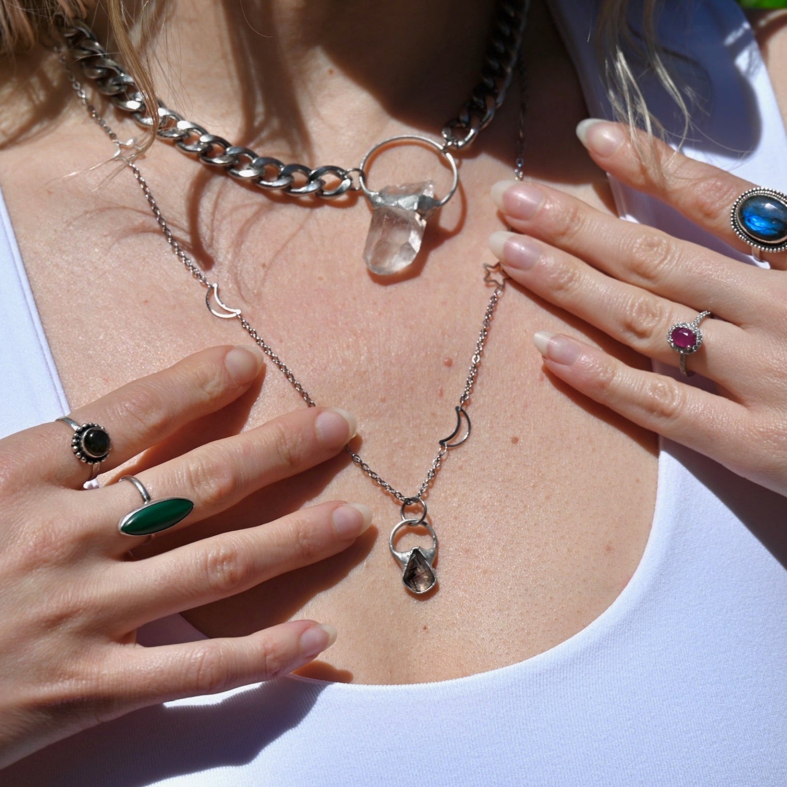 Someone wearing the Black Rutile Sterling Silver Celestial Necklace and the Clear Quartz Athena Thick Chain Necklace.