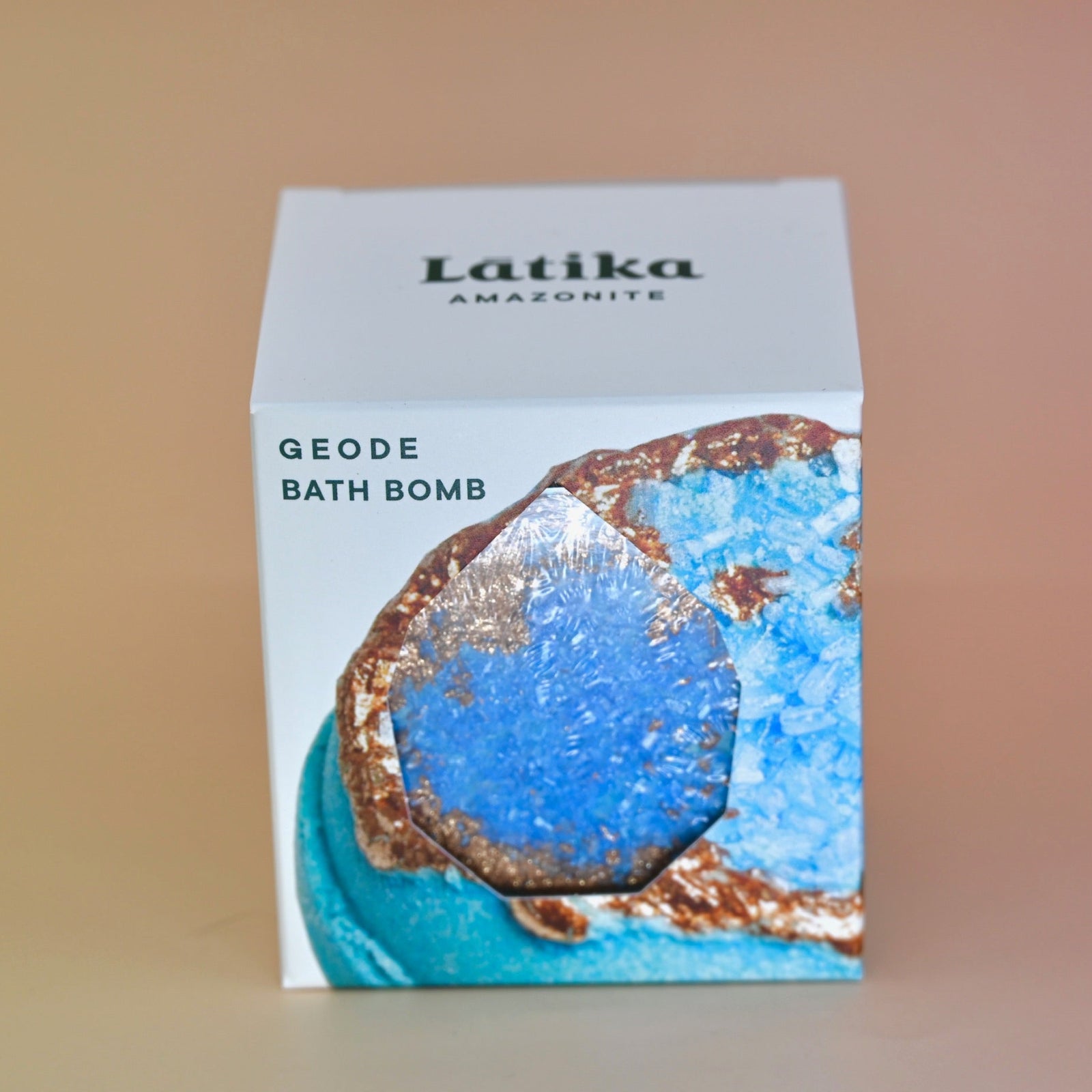 The Amazonite Crystal Bath Bomb on a pink background.