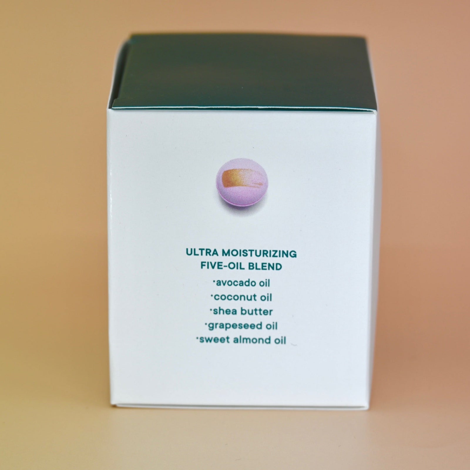 The side of the box of the Hand-Painted Lavender Bath Bomb on a dusty pink background.