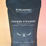 The Black Hatchet Shower Steamers - Grapefruit & Mint Shower Steamers on a pink background.