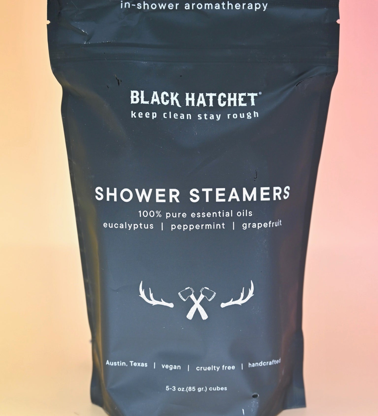 The Black Hatchet Shower Steamers - Grapefruit & Mint Shower Steamers on a pink background.