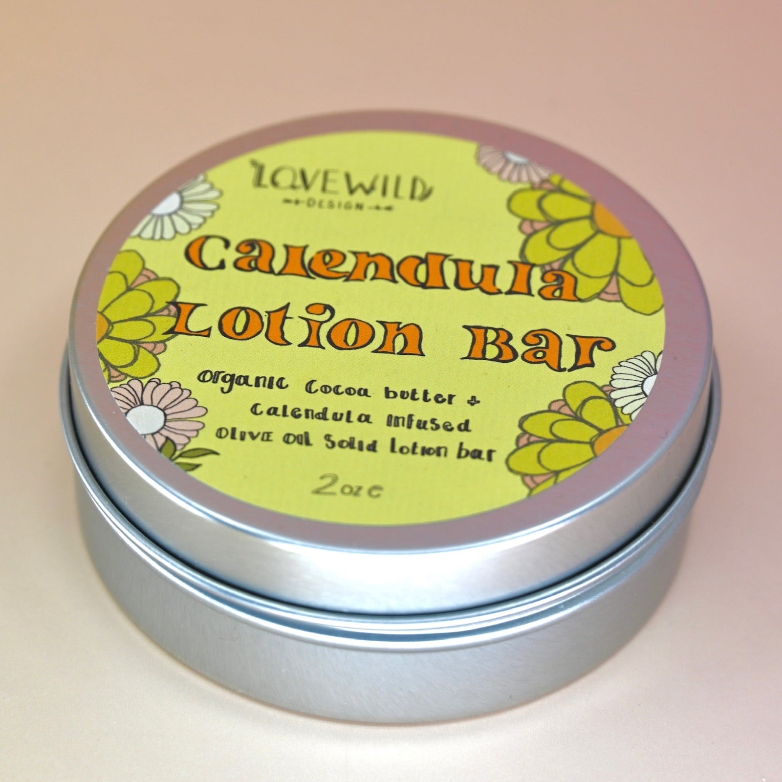 The Calendula Lotion Bar on a pink and yellow background.