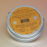 The back of the Calendula Lotion Bar on a pink and yellow background