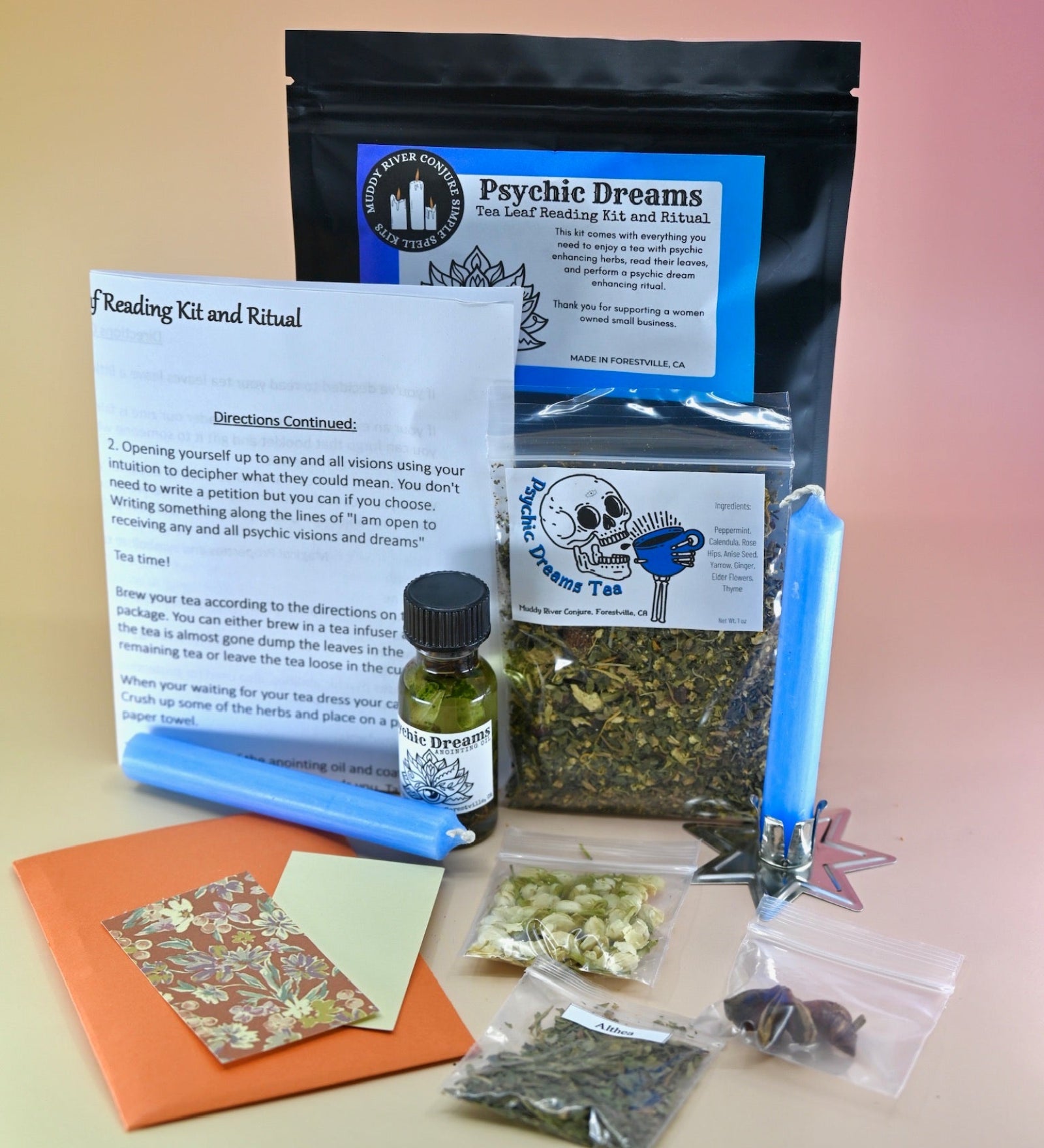 The Psychic Dreams Tea Leaf Reading and Ritual Kit on a pink and yellow background with all its contents.