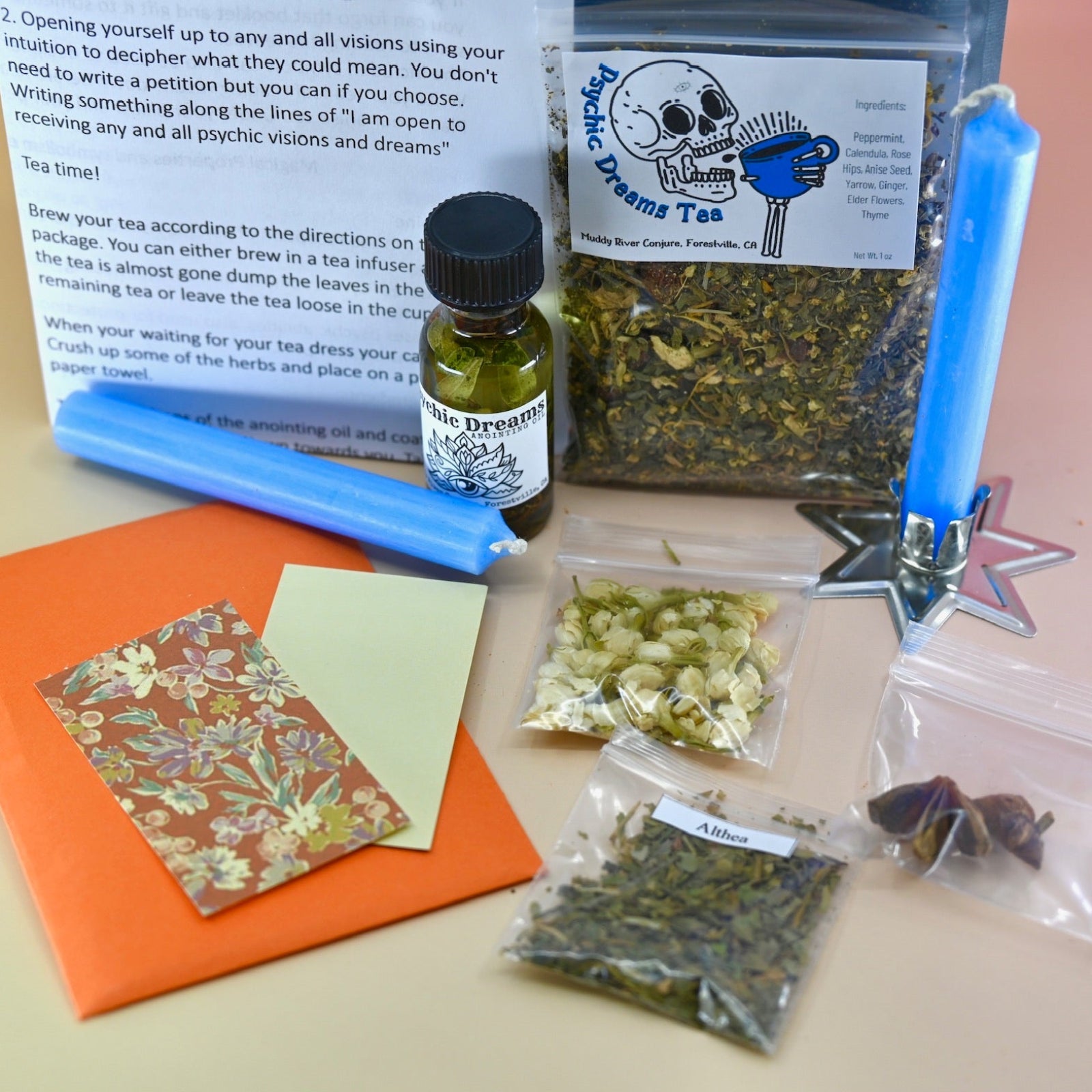 The Psychic Dreams Tea Leaf Reading and Ritual Kit on a pink and yellow background with all its contents.