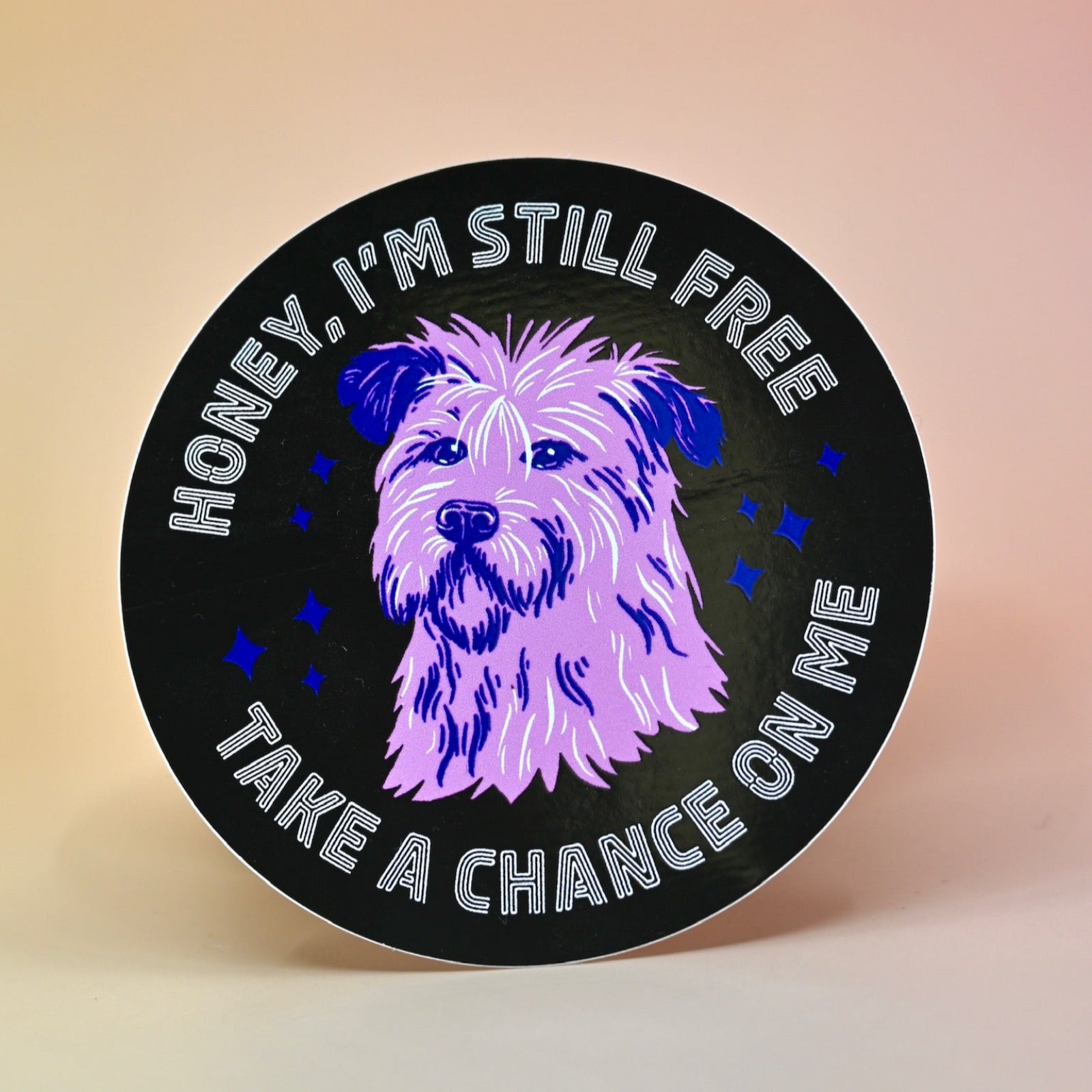 The Honey I'm Still Free Dog Sticker on a light peach-colored background.