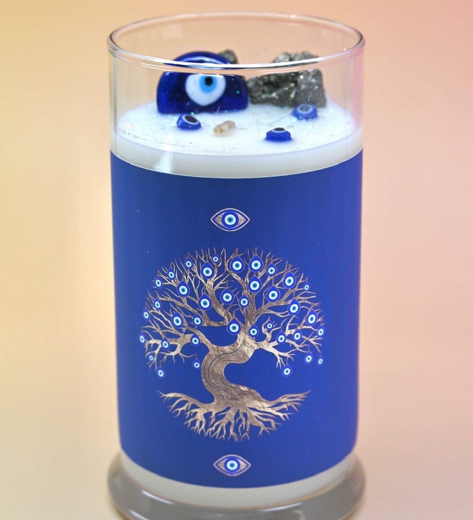 The Affirmation Evil Eye Candle - 21oz Candle on a pink background.