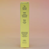The back of the box of the Hinoki Sesame 5ml Unisex Eau de Parfum Travel Sprayer on a pink and yellow background.