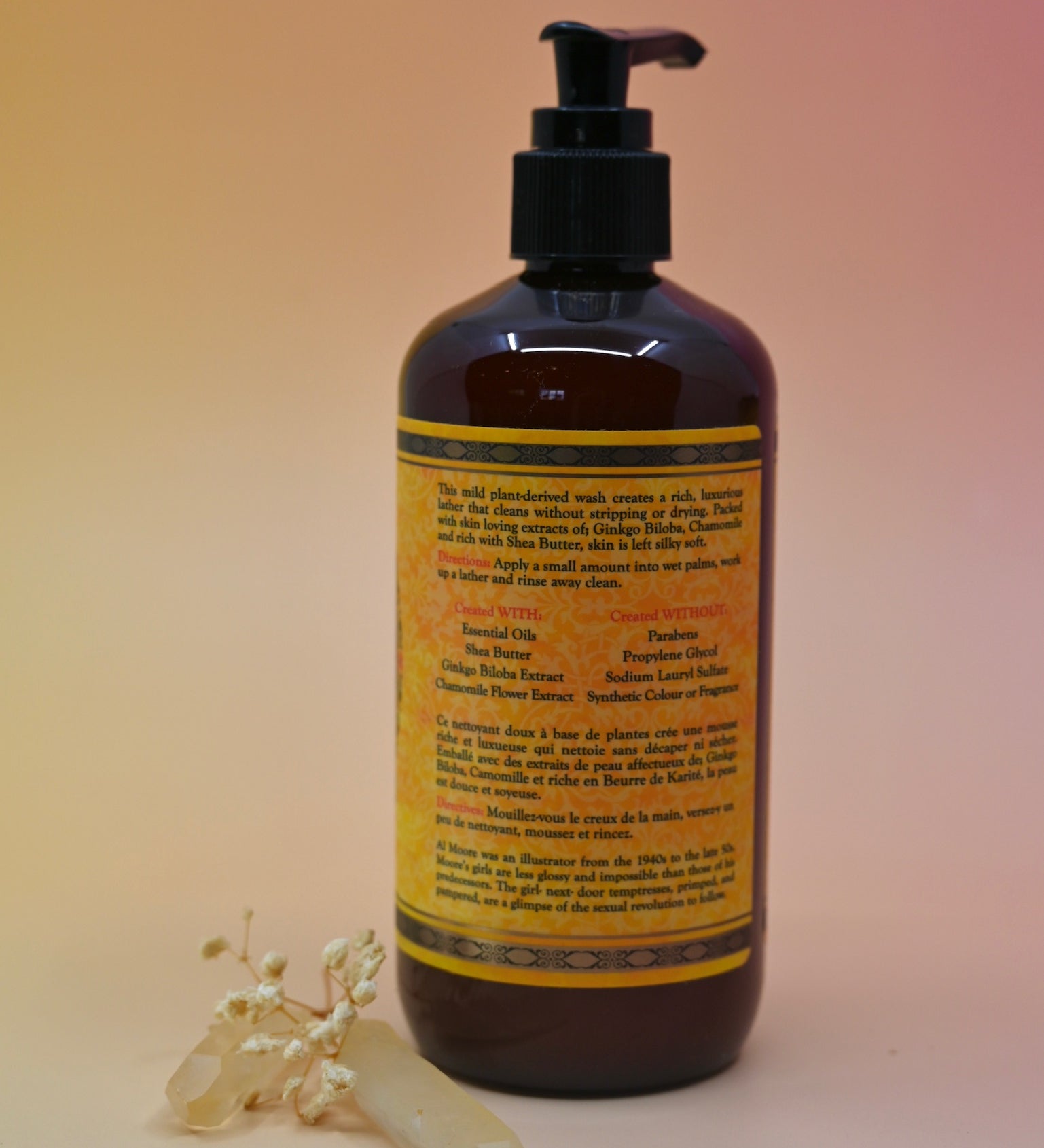 The back of the Essential Oil Cleansing Hand & Body Wash with a crystal in front of it on a light pink background.