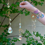 The Fairy Lights Suncatchers - Pack of 7 Suncatchers in front of a cream-colored brick wall with greenery.