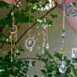 The Fairy Lights Suncatchers - Pack of 7 Suncatchers in front of a cream-colored brick wall with greenery.