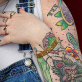 Gold mesh bracelet styled with gold rings and tattoos