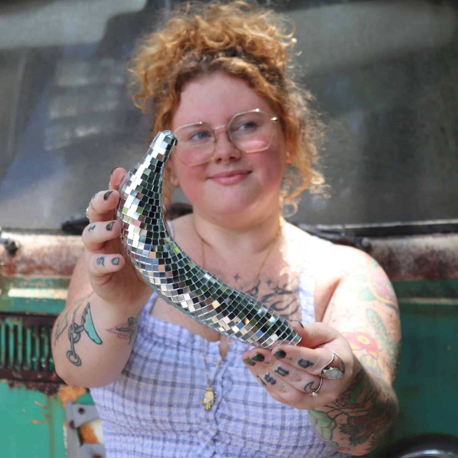 Person holding a silver disco ball-shaped object with a blurred background