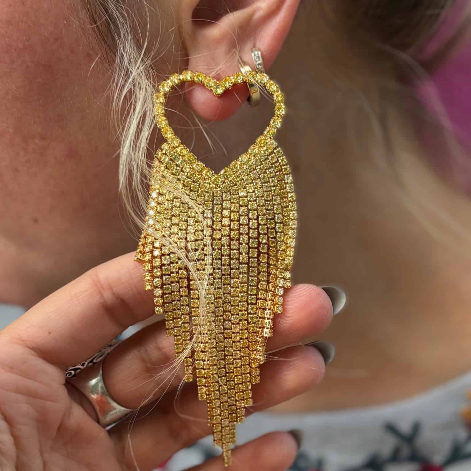 Emma Pills Do Not Party Without Them heart-shaped disco earrings with gold and crystal fringe worn by model close up earrings