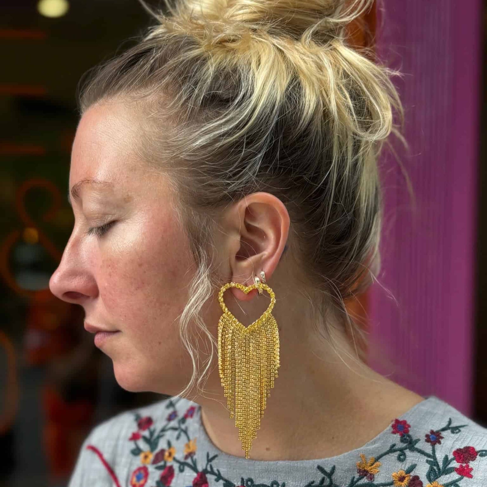 Emma Pills Do Not Party Without Them heart-shaped disco earrings with gold and crystal fringe worn by model