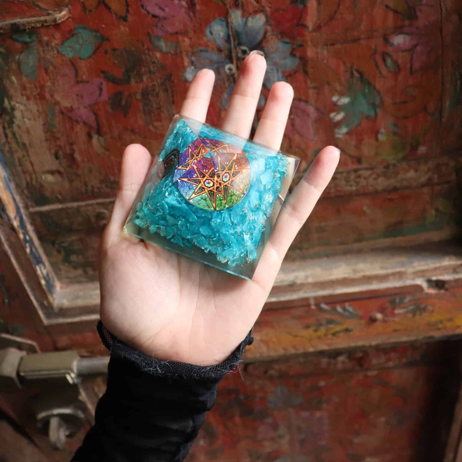 Blue agate orgone pyramid held in hand for meditation