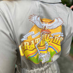 Beige jacket with a colorful graphic design on the back featuring an eagle and text.