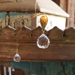 An up-close image of someone holding the Prisma Hanging #15 in front of a wooden background.