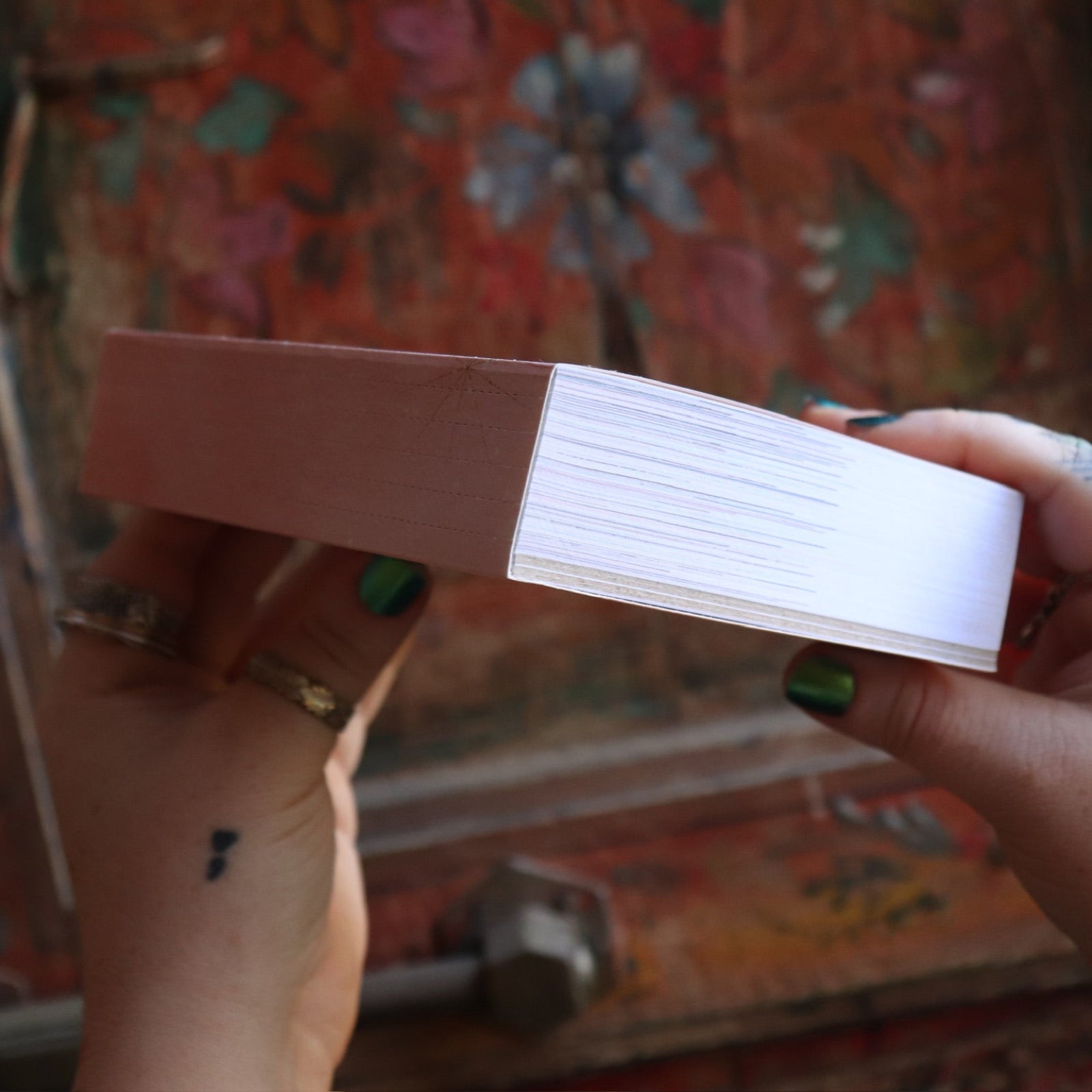 Someone holding the Year of the Witch 2026 Day-to-Day Calendar up in front of a door, showing off the side.