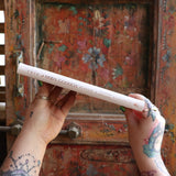 Someone holding the 2026 Moon Goddess Northern Hemisphere Planner Calendar in front of a wooden door, showing off the side.