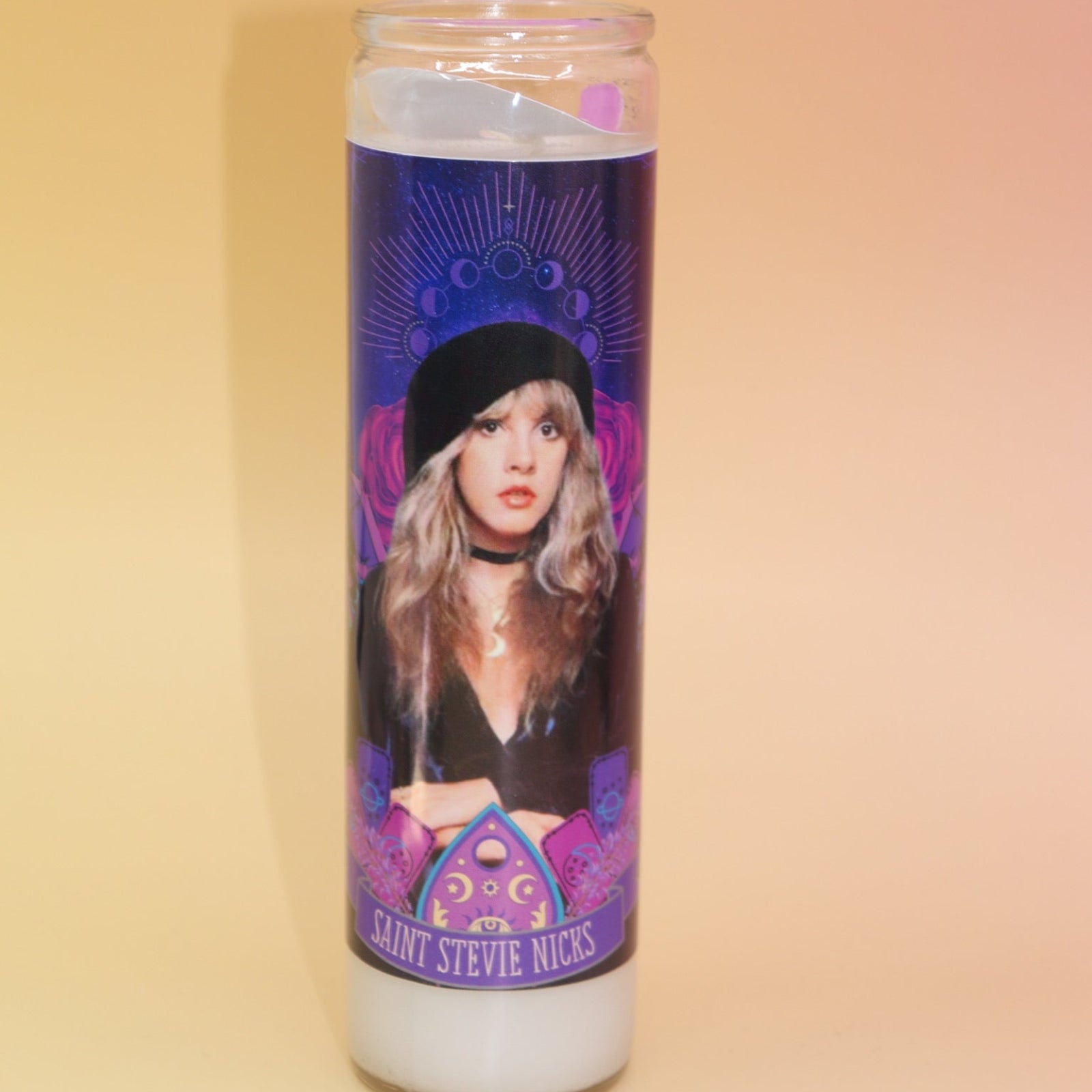 The Stevie Nicks Altar Candle on a pink and yellow background.