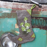 The Handmade Green Mushroom Wool Felt Boho Stocking hanging in front of a teal vintage Volkswagen bus.