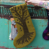 Someone holding the Tree of Life Mystical Felt Stocking in front of a vintage teal Volkswagen bus.