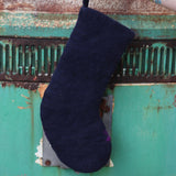 Someone holding the cat Folk Art Embroidered Pure Wool Felt Handcrafted Stocking in front of a vintage teal Volkswagen bus, showing off the back.