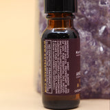 The Venus - A Love Oil Reiki Charged Anointing Oil in front of an amethyst tower all on a pink and yellow background.