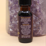 The Break Patterns & Addictions Oil Reiki Charged Anointing Oil in front of an amethyst tower all on a pink and yellow background.