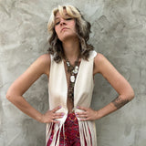 A woman wearing the cream Faux Suede Long Fringe Open Front Western Vest.